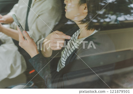 Giving directions while looking at a map app on a smartphone in the passenger seat Giving directions while looking at a map app on a smartphone in the passenger seat 121879501