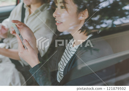 A passenger in the front seat navigates using a map app on his smartphone A passenger in the front seat navigates using a map app on his smartphone 121879502
