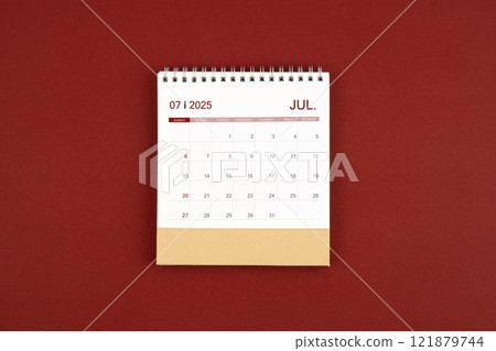July 2025 desk calendar on red leather. July 2025 desk calendar on red leather. 121879744