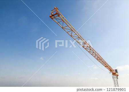 Industrial construction crane with blue sky background at building site 121879901