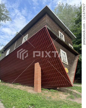 Upside-Down Wooden House with Red Roof Panels 121879927