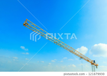 Industrial construction crane with blue sky background at building site 121879930