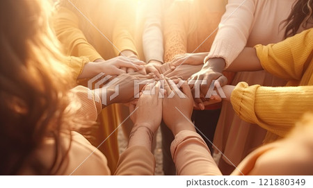 A diverse group of individuals of different races and genders join hands in a circle, symbolizing 121880349