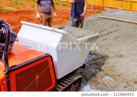 Workers are pouring fresh concrete using specialized rubber concrete truck at building site Workers are pouring fresh concrete using specialized rubber concrete truck at building site 121880455