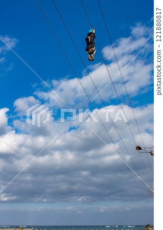 White sand beach, blue sea and sky. Zip line over the sea at Sheraton Okinawa Sunmarina Resort. 121880817