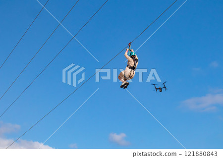 White sand beach, blue sea and sky. Zip line over the sea at Sheraton Okinawa Sunmarina Resort. 121880843