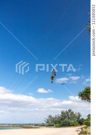 White sand beach, blue sea and sky. Zip line over the sea at Sheraton Okinawa Sunmarina Resort. 121880852