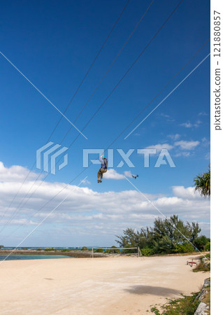 White sand beach, blue sea and sky. Zip line over the sea at Sheraton Okinawa Sunmarina Resort. White sand beach, blue sea and sky. Zip line over the sea at Sheraton Okinawa Sunmarina Resort. 121880857