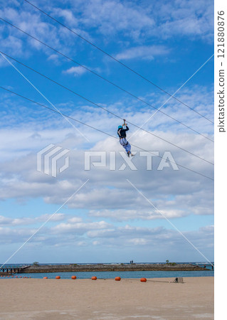 White sand beach, blue sea and sky. Zip line over the sea at Sheraton Okinawa Sunmarina Resort. White sand beach, blue sea and sky. Zip line over the sea at Sheraton Okinawa Sunmarina Resort. 121880876