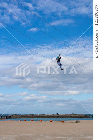 White sand beach, blue sea and sky. Zip line over the sea at Sheraton Okinawa Sunmarina Resort. White sand beach, blue sea and sky. Zip line over the sea at Sheraton Okinawa Sunmarina Resort. 121880877