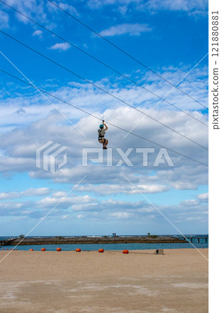 White sand beach, blue sea and sky. Zip line over the sea at Sheraton Okinawa Sunmarina Resort. White sand beach, blue sea and sky. Zip line over the sea at Sheraton Okinawa Sunmarina Resort. 121880881