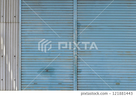 Light blue shutters of an old warehouse Light blue shutters of an old warehouse 121881443