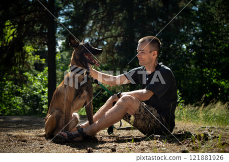young Caucasian hipster spends time with his dog in the park on a sunny summer day. The concept of a pet as a family member young Caucasian hipster spends time with his dog in the park on a sunny summer day. The concept of a pet as a family member 121881926