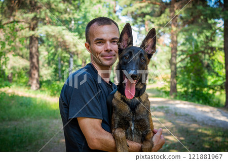 young Caucasian hipster spends time with his dog in the park on a sunny summer day. The concept of a pet as a family member 121881967
