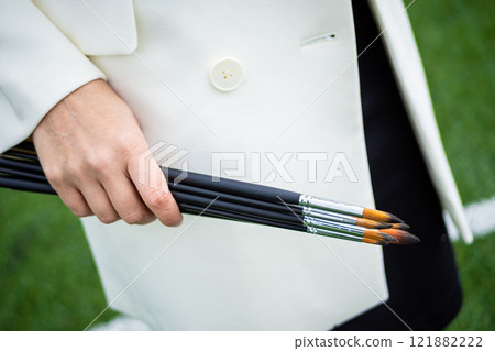Brunette, female artist paints in nature. 121882222