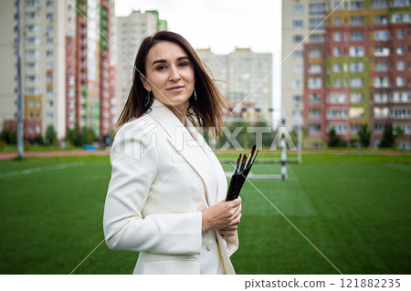 Brunette, female artist paints in nature. 121882235
