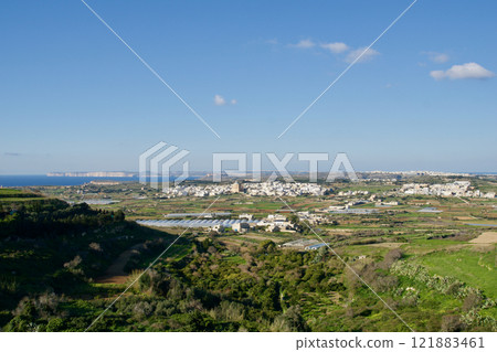 Malta, January 2, 2020: Scenic View of a Green Valley with White Houses and the Mediterranean Sea 121883461