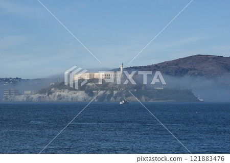 SAN FRANCISCO, CALIFORNIA, UNITED STATES - NOV 25th, 2018: Alcatraz prison in fog panorama during a sunny day in November as seen from pier 39 121883476