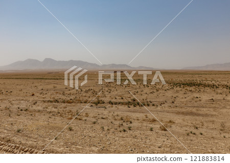 Arid landscape in Kunduz, Afghanistan features distant mountains and sparse vegetation Arid landscape in Kunduz, Afghanistan features distant mountains and sparse vegetation 121883814