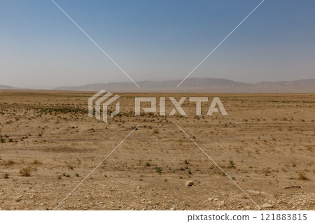 Arid Kunduz Province, Afghanistan, features sparse vegetation and distant mountains Arid Kunduz Province, Afghanistan, features sparse vegetation and distant mountains 121883815