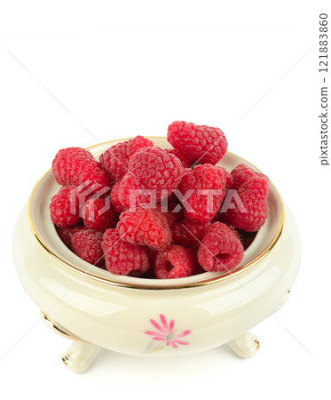 Raspberries in a vintage porcelain bowl isolated on a white background. 121883860