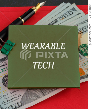 Wearable computing concept. The concept of technology . WEARABLE TECH Concept Text written on a sticker on the background of dollar bills Wearable computing concept. The concept of technology . WEARABLE TECH Concept Text written on a sticker on the background of dollar bills 121884885