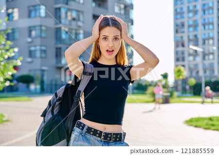 Surprised teenage girl student with backpack outdoor 121885559