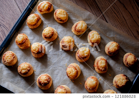 Pogaca stuffed with cheese. A full tray of fresh Pogaca, salty buns with cheese - Pogace. 121886028