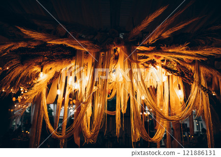 A stunning chandelier, decorated with lights, hangs from the ceiling A stunning chandelier, decorated with lights, hangs from the ceiling 121886131