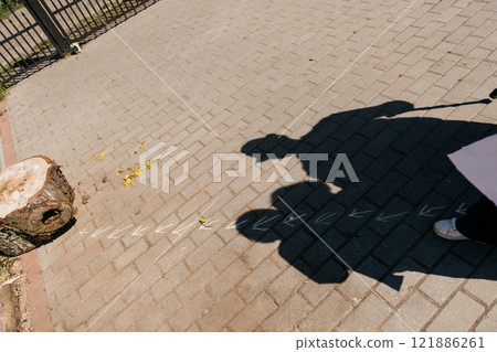 A long shadow of a person is cast on the brick sidewalk surface A long shadow of a person is cast on the brick sidewalk surface 121886261
