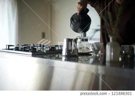 Pouring boiling water into a coffee pot Pouring boiling water into a coffee pot 121886301