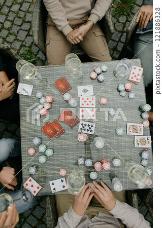 A diverse group is around a large table, fully engaged in poker A diverse group is around a large table, fully engaged in poker 121886328