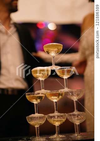 A stunning pyramid of champagne glasses on a beautifully arranged table A stunning pyramid of champagne glasses on a beautifully arranged table 121886389