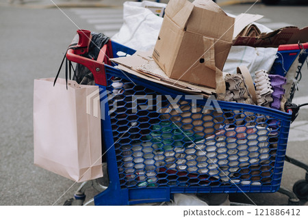 A cart filled with boxes and bags is parked by the road A cart filled with boxes and bags is parked by the road 121886412