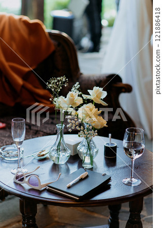 A decorated table with a vase of flowers and wine glasses 121886418
