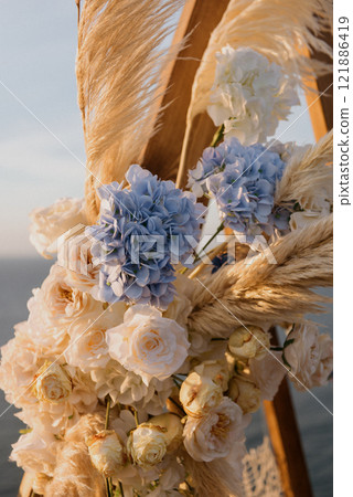 A beautiful wooden arch decorated with flowers and swaying grass 121886419