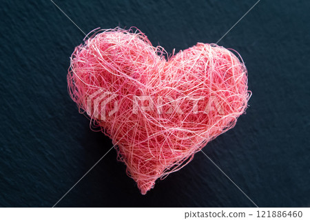 Heart shape made of material fabric on the black stone background with copyspace. Concept of Valentine's day and romantic love. Heart shape made of material fabric on the black stone background with copyspace. Concept of Valentine's day and romantic love. 121886460