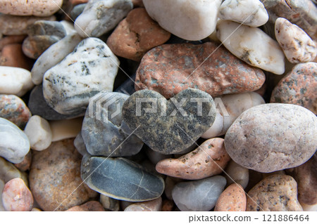 Gray heart on other stones near the river. Stones background. Concept of Valentine's day and romantic love. 121886464