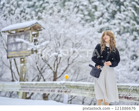 Woman walking in the snow 121886676