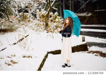 Woman walking in the snow 121886784