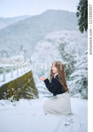Woman walking in the snow 121886807