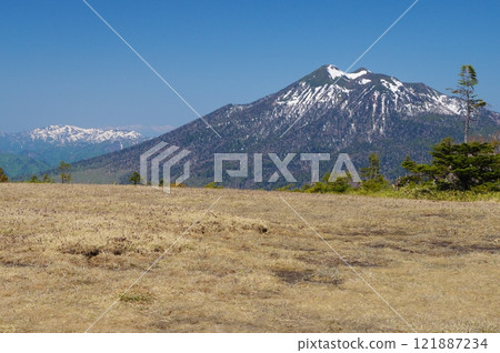 Snow-covered Mt. Hiuchigatake seen from Ayamedaira in Oze in early spring 121887234