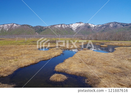 The ponds of Ozegahara in early spring and the remaining snow on Mount Keikaku 121887616