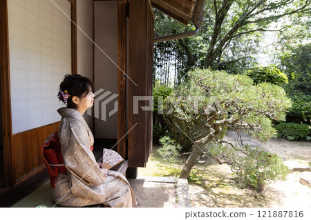 A woman in a kimono sitting on a veranda (profile) A woman in a kimono sitting on a veranda (profile) 121887816