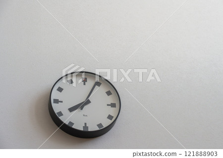 Wall clock on a white wall 121888903