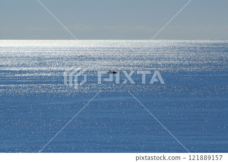 A fishing boat sailing on the sparkling sea of early spring A fishing boat sailing on the sparkling sea of early spring 121889157