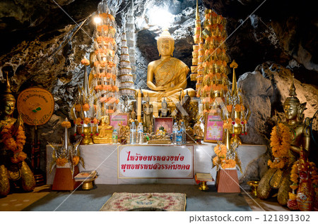 Buddha statue surrounded by offerings in Wat Khao Phrom Sawan cave, Saraburi Thailand on October 07 2023 Buddha statue surrounded by offerings in Wat Khao Phrom Sawan cave, Saraburi Thailand on October 07 2023 121891302