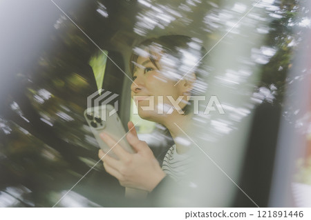 乘客座位上的一位女士使用智慧型手機地圖應用程式搜尋路線 121891446
