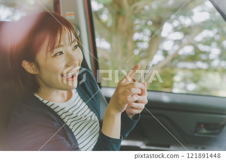 乘客座位上的一位女士使用智慧型手機地圖應用程式搜尋路線 121891448