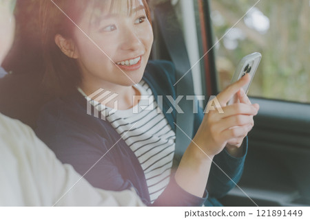 乘客座位上的一位女士使用智慧型手機地圖應用程式搜尋路線 121891449